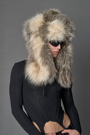 Model wearing oversized brown and cream faux-fur hood hat with drawstrings