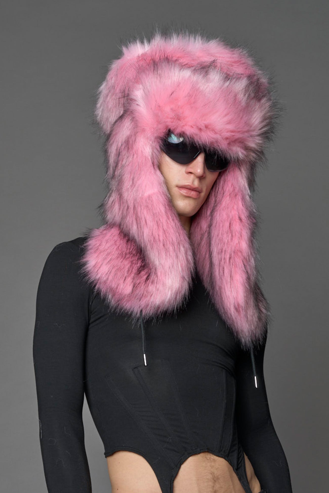 Model wearing oversized pink and cream faux-fur hood hat with drawstrings