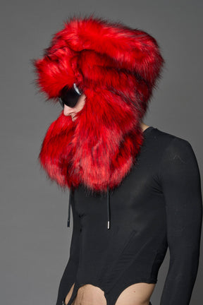 Model wearing oversized red and cream faux-fur hood hat with drawstrings