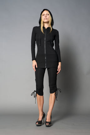 model wearing black soft jersey short dress with hood and backless cut out