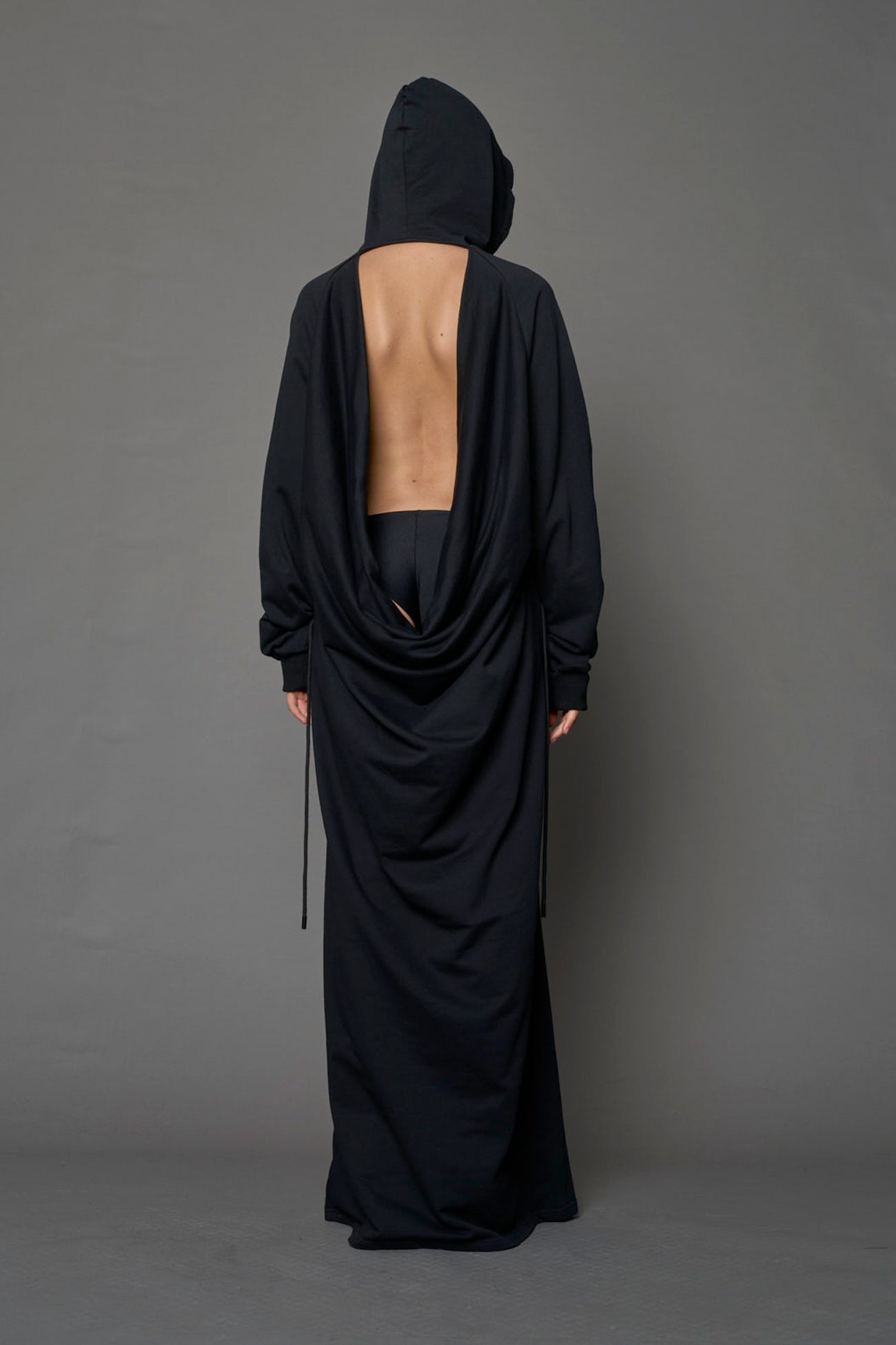 Model wearing a long black hoodie dress with a goth-inspired print detail
