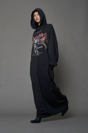 Model wearing a long black hoodie dress with a goth-inspired print detail
