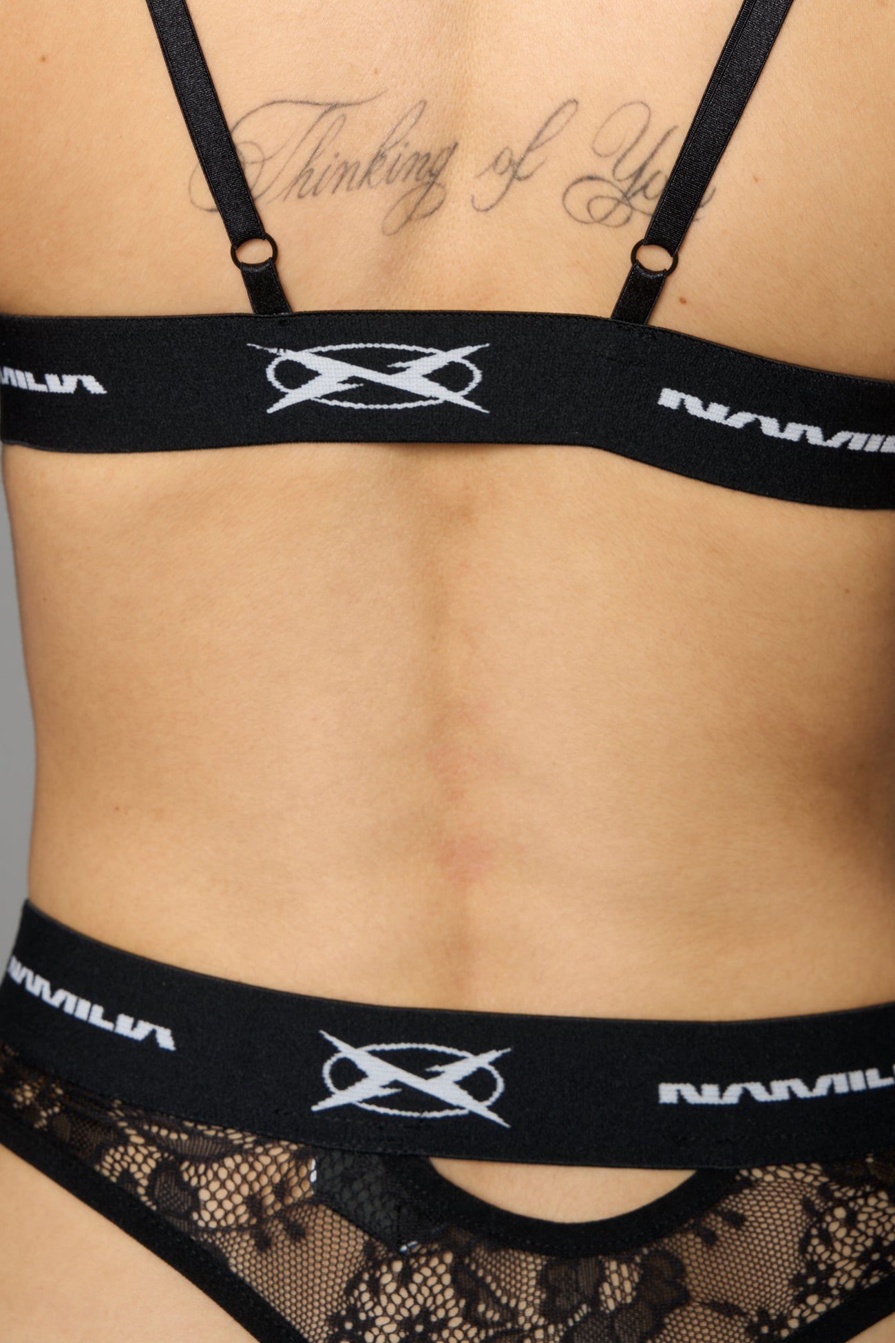 Black Namilia lace thong with floral mesh, logo waistband and cut-out details on front and back