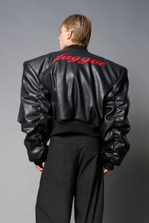 model wears red oversize cropped vegan leather bomber with exaggerated shoulderpads and ruching on sleeves.