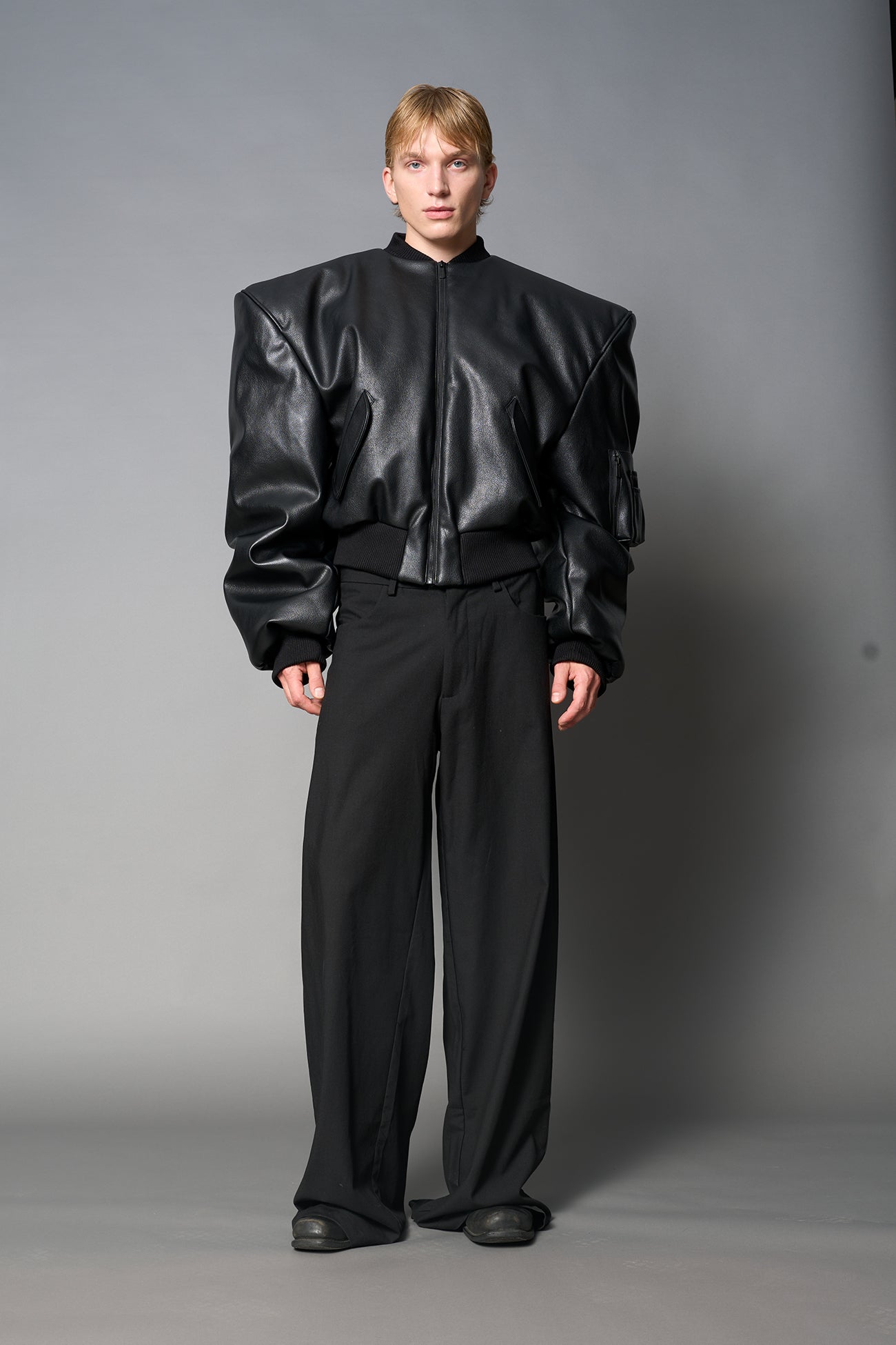 model wears red oversize cropped vegan leather bomber with exaggerated shoulderpads and ruching on sleeves.