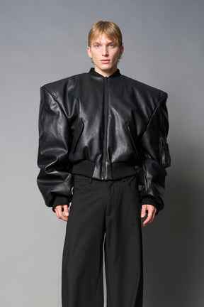 model wears red oversize cropped vegan leather bomber with exaggerated shoulderpads and ruching on sleeves.