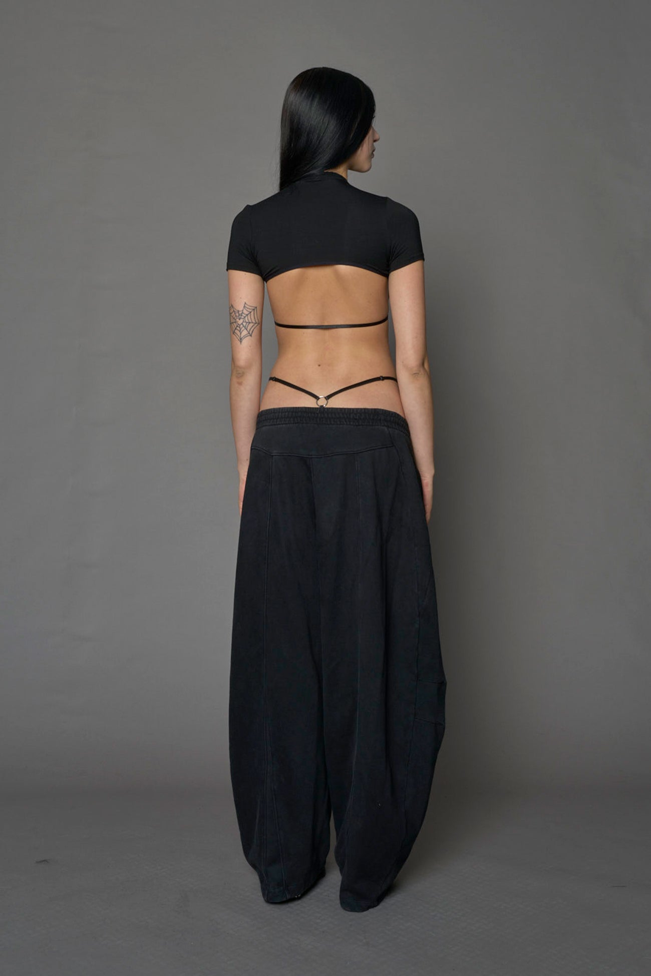 Model wearing a black form fitted T-Shirt bodysuit with lace details