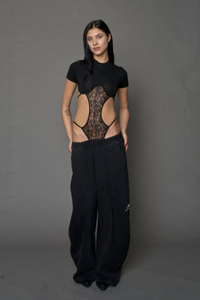 Model wearing a black form fitted T-Shirt bodysuit with lace details