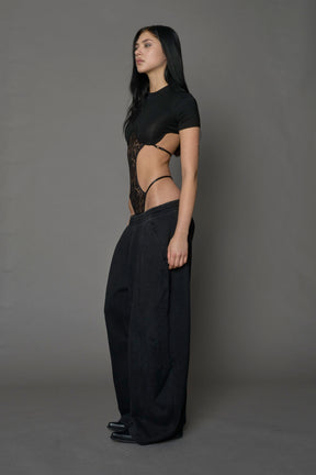 Model wearing a black form fitted T-Shirt bodysuit with lace details