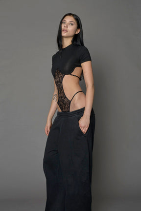 Model wearing a black form fitted T-Shirt bodysuit with lace details