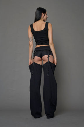 model wearing black jogger-inspired chaps with a lace suspender belt 