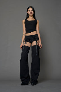 model wearing black jogger-inspired chaps with a lace suspender belt 