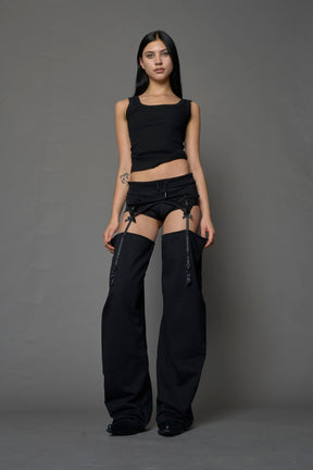 model wearing black jogger-inspired chaps with a lace suspender belt 
