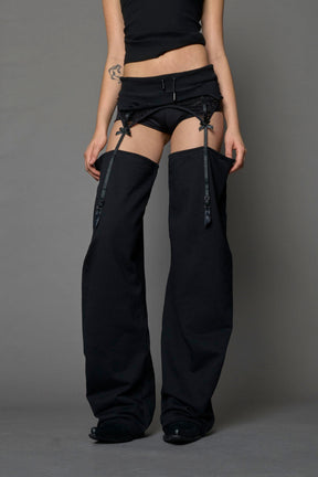 model wearing black jogger-inspired chaps with a lace suspender belt 