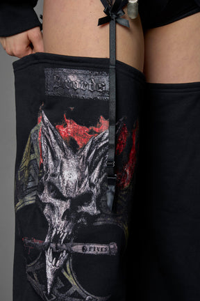 detail of black jogger-inspired chaps with a lace suspender belt and goth-inspired print