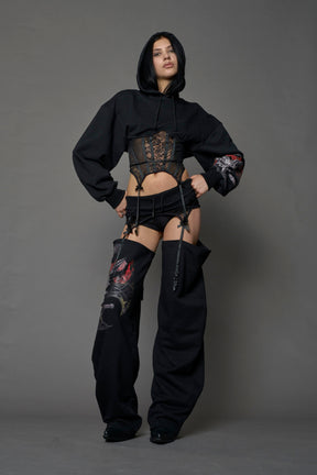 model wearing black jogger-inspired chaps with a lace suspender belt and goth-inspired print