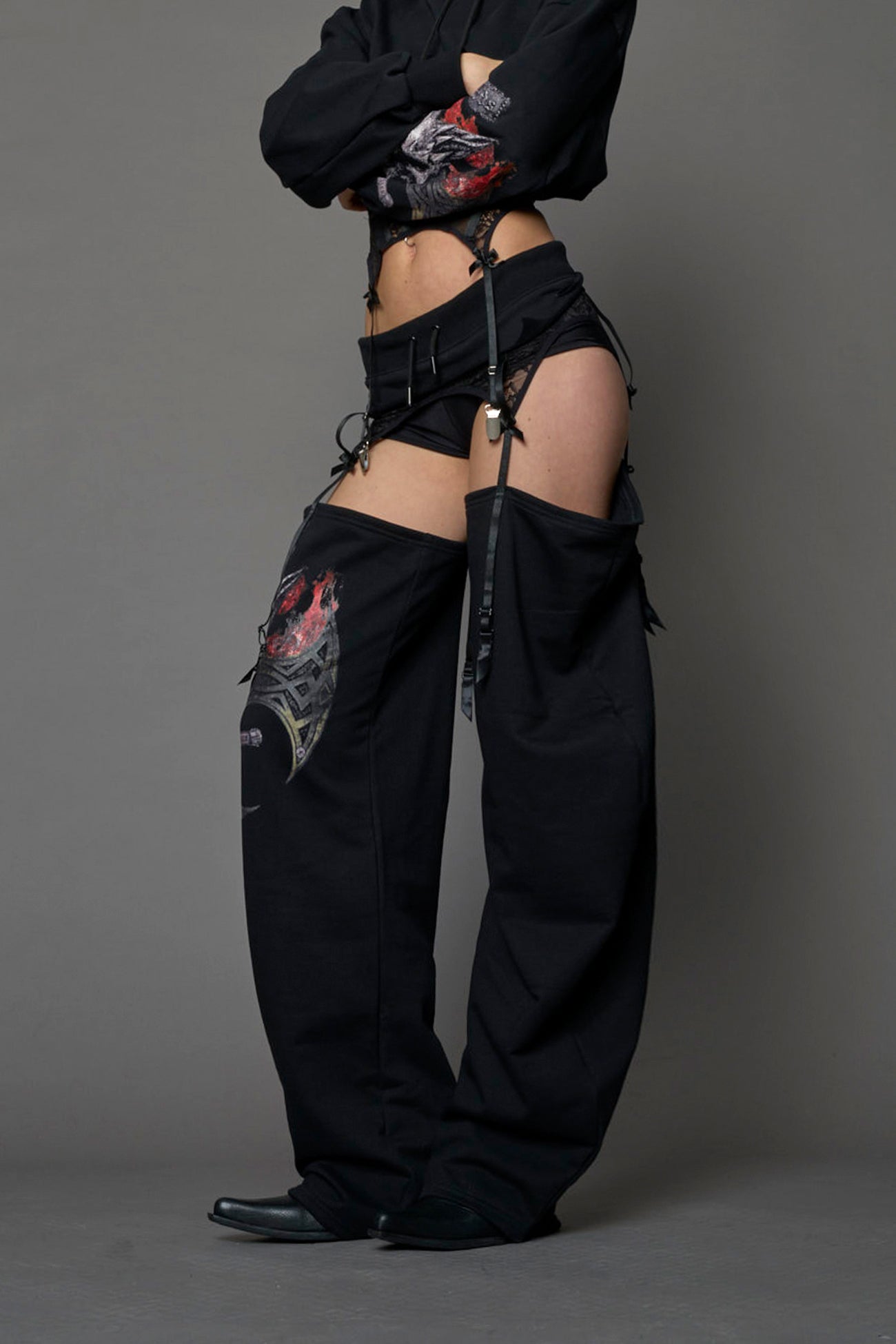 model wearing black jogger-inspired chaps with a lace suspender belt and goth-inspired print