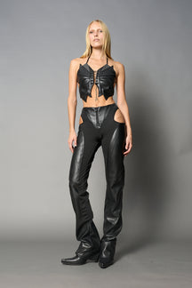 Black cut-out flare pants with graphic details, vegan leather panels, and low-rise waist – edgy motocross-inspired trousers for men’s streetwear or festival looks.