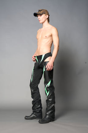 Green cut-out flare pants with graphic details, vegan leather panels, and low-rise waist – edgy motocross-inspired trousers for men’s streetwear or festival looks.