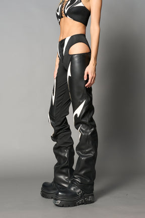 white cut-out flare pants with graphic details, vegan leather panels, and low-rise waist – edgy motocross-inspired trousers for men’s streetwear or festival looks.