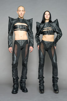 Model wearing high-waisted black washed vegan leather pants with mesh cutouts, moto-inspired paneling, and flared stacked legs – edgy streetwear trousers styled with chunky platform boots