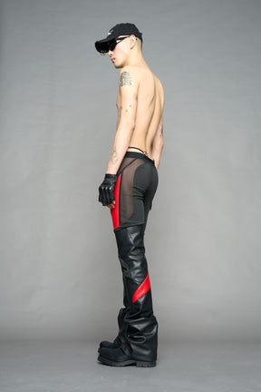 Model wearing high-waisted black red vegan leather pants with mesh cutouts, moto-inspired paneling, and flared stacked legs – edgy streetwear trousers styled with chunky platform boots