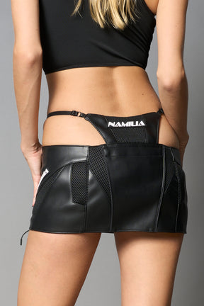 Black vegan leather moto thong mini skirt with lace-up sides, cut-out hips, and zip front – edgy Y2K streetwear skirt for clubwear or festival looks.

