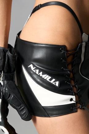 white vegan leather moto thong mini skirt with lace-up sides, cut-out hips, and zip front – edgy Y2K streetwear skirt for clubwear or festival looks.
