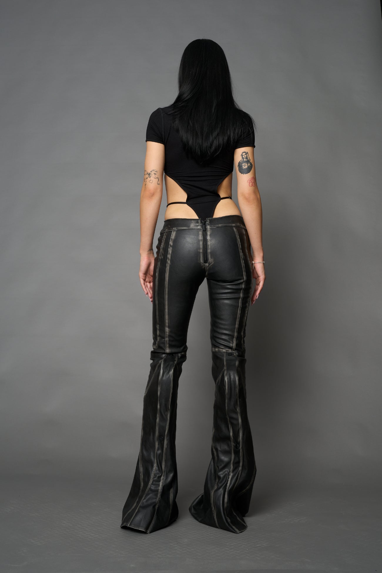 Black washed vegan leather stretch mutant pants with high waist, ribbed knee panels, and exaggerated flared legs by Namilia