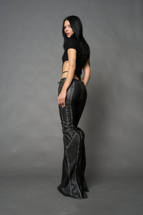 Black washed vegan leather stretch mutant pants with high waist, ribbed knee panels, and exaggerated flared legs by Namilia