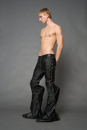 Black washed vegan leather stretch mutant pants with high waist, ribbed knee panels, and exaggerated flared legs by Namilia