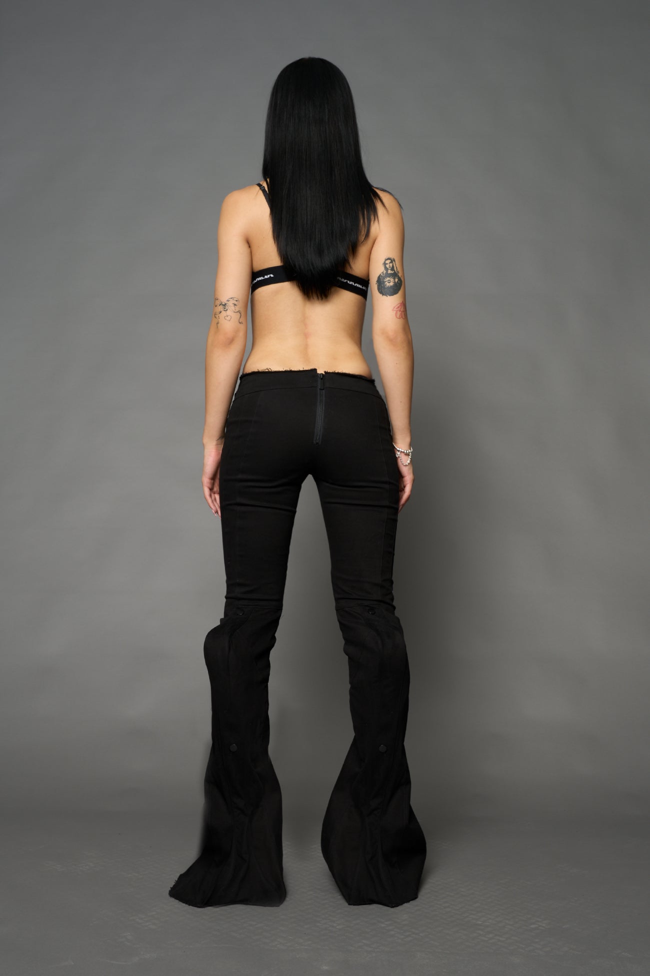 Black cotton stretch mutant pants with low waist, ribbed knee panels, and exaggerated flared legs by Namilia