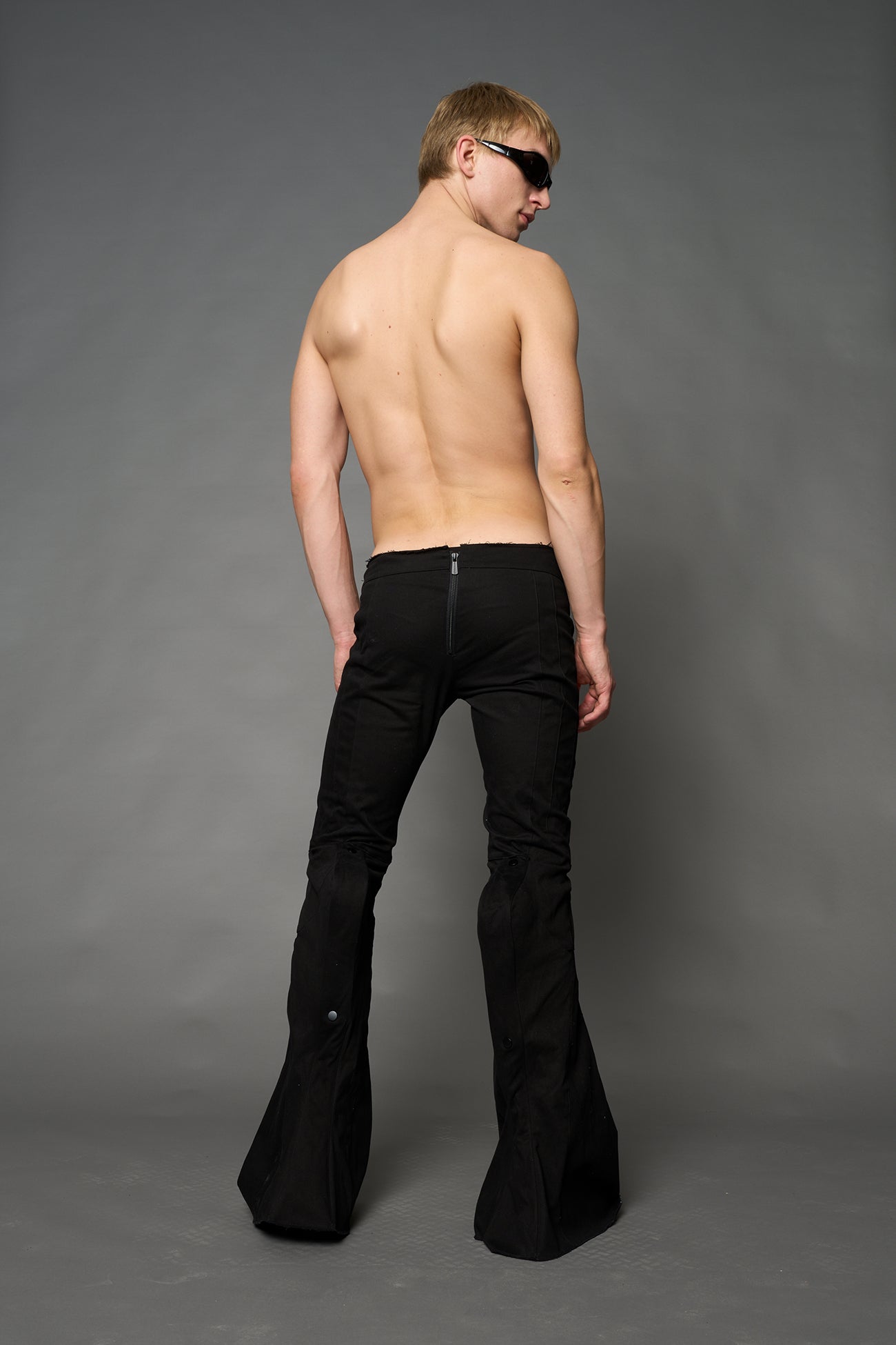 Black cotton stretch mutant pants with low waist, ribbed knee panels, and exaggerated flared legs by Namilia