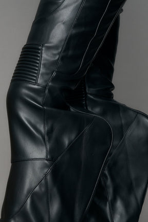 Black vegan leather stretch mutant pants with high waist, ribbed knee panels, and exaggerated flared legs by Namilia