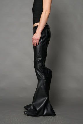Black vegan leather stretch mutant pants with high waist, ribbed knee panels, and exaggerated flared legs by Namilia