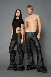 Black washed vegan leather stretch mutant pants with high waist, ribbed knee panels, and exaggerated flared legs by Namilia