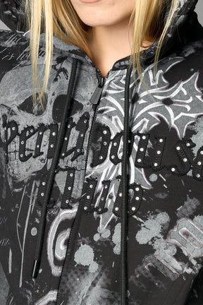 Model wearing a black print cropped hoodie with exaggerated spike shoulders, drawstring hood