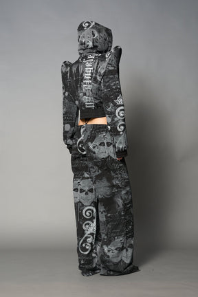 Model wearing a black print cropped hoodie with exaggerated spike shoulders, drawstring hood