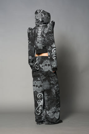 Model wearing a black print cropped hoodie with exaggerated spike shoulders, drawstring hood