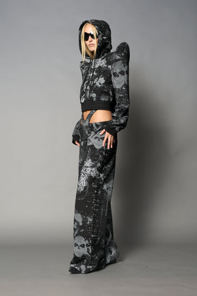 Model wearing a black print cropped hoodie with exaggerated spike shoulders, drawstring hood