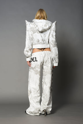 Model wearing a white print cropped hoodie with exaggerated spike shoulders, drawstring hood