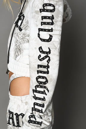 Model wearing a white print cropped hoodie with exaggerated spike shoulders, drawstring hood