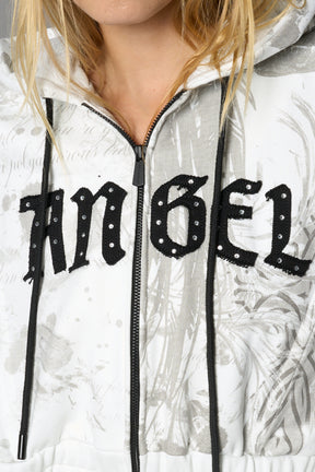 Model wearing a white print cropped hoodie with exaggerated spike shoulders, drawstring hood