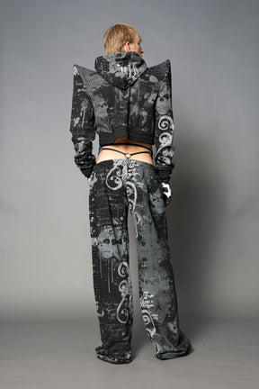 Model wearing a black print cropped hoodie with exaggerated spike shoulders, drawstring hood