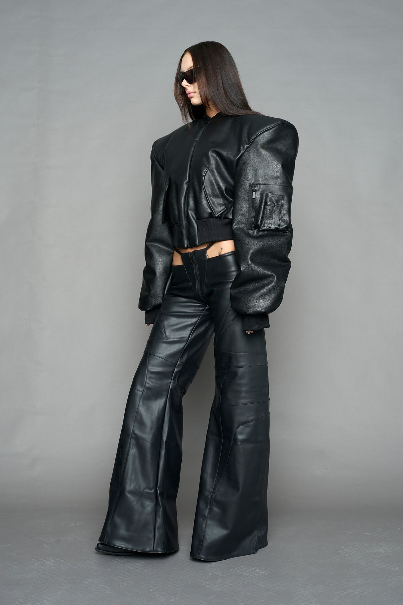 model wearing black vegan leather bomber jacket with large shoulders