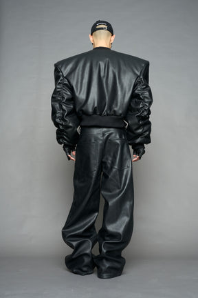 model wearing black vegan leather bomber jacket with large shoulders