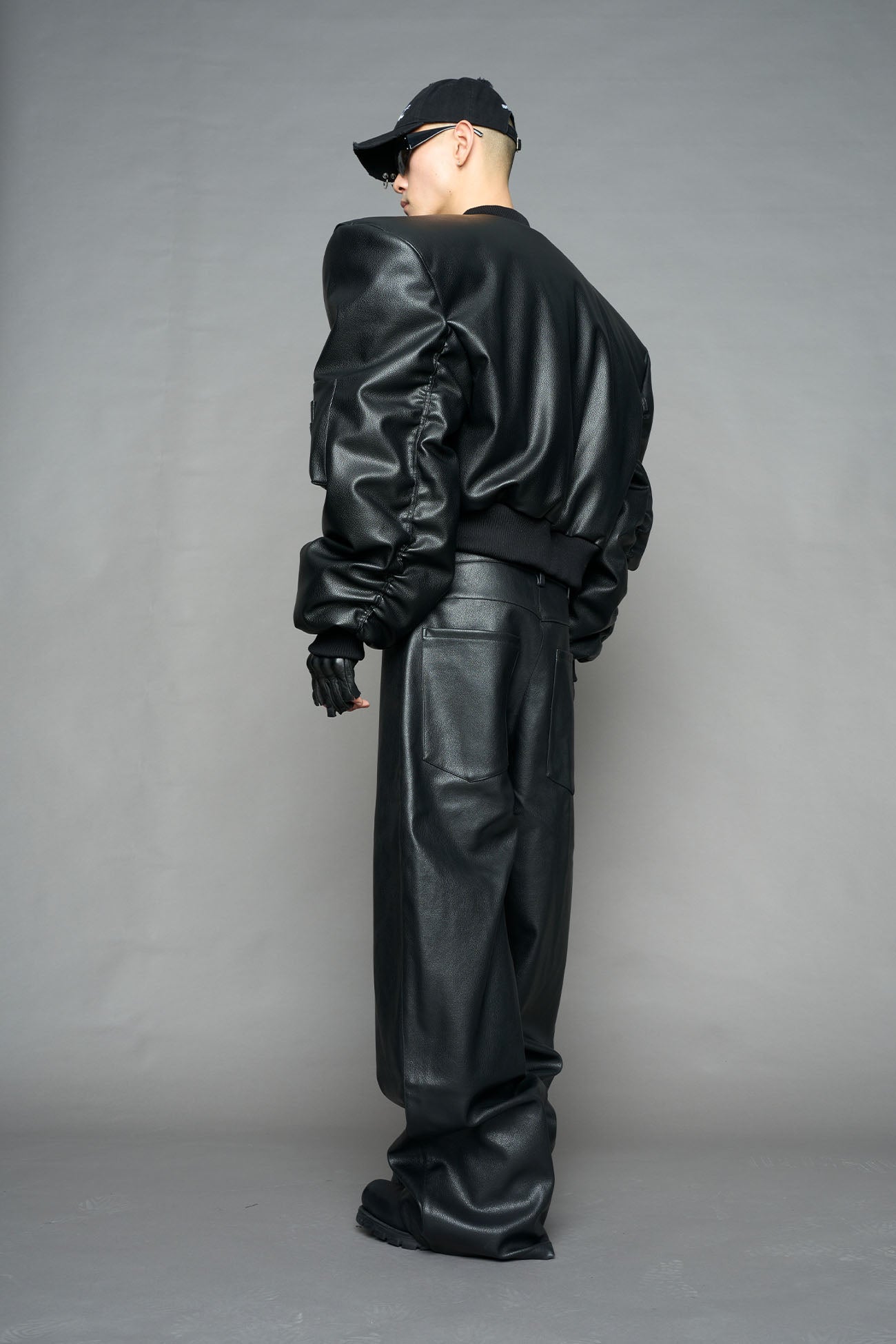 model wearing black vegan leather bomber jacket with large shoulders
