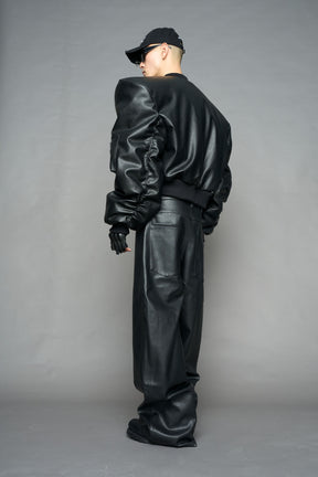 model wearing black vegan leather bomber jacket with large shoulders