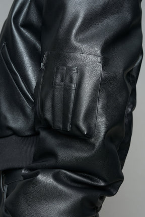 model wearing black vegan leather bomber jacket with large shoulders