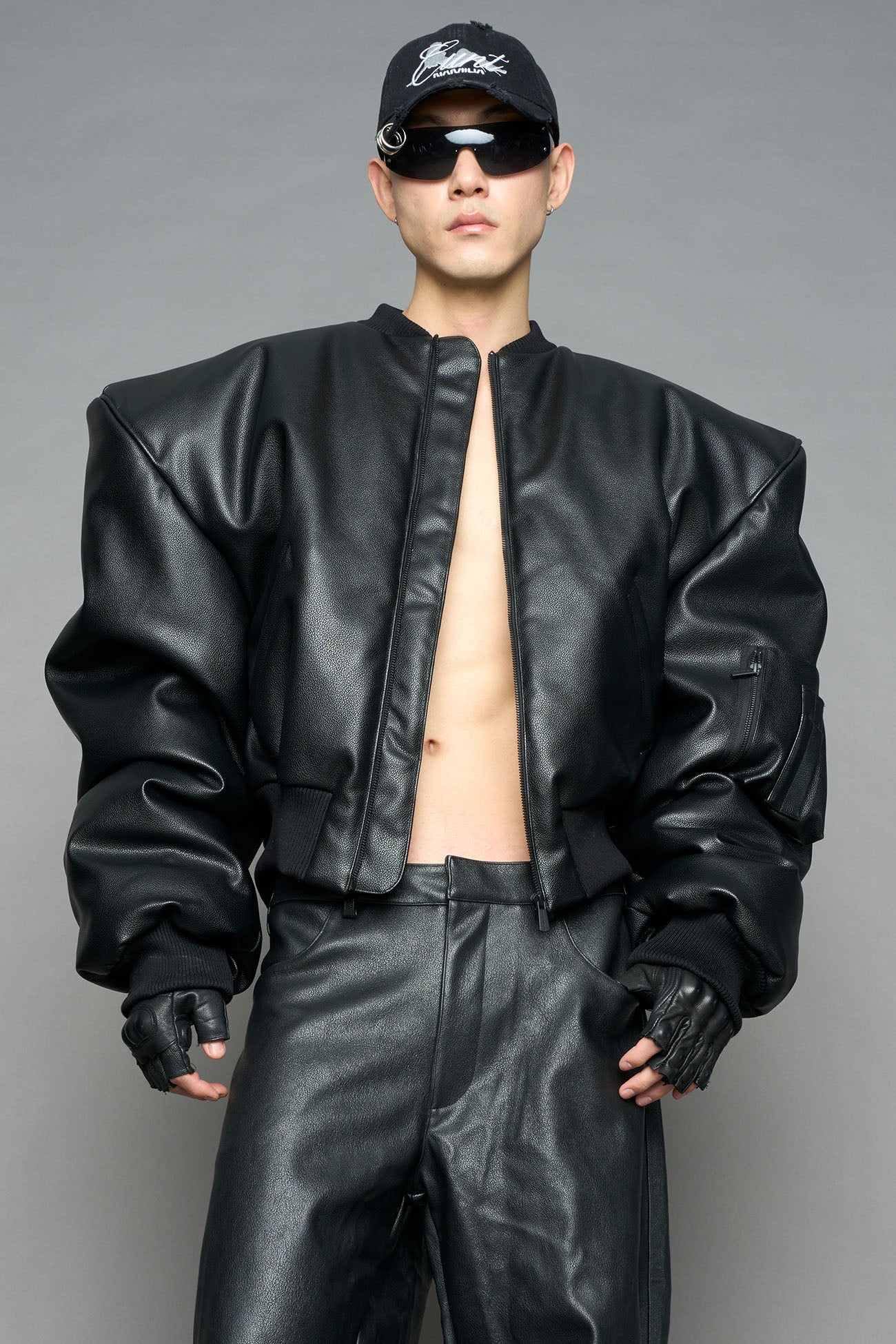 model wearing black vegan leather bomber jacket with large shoulders